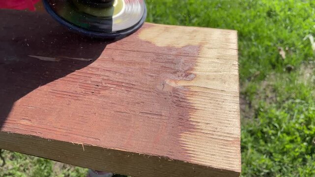 Close-up video of grinding a wooden plank with an angle grinder.