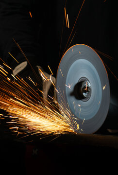 Close-up of angle grinder producing sparks while cutting steel