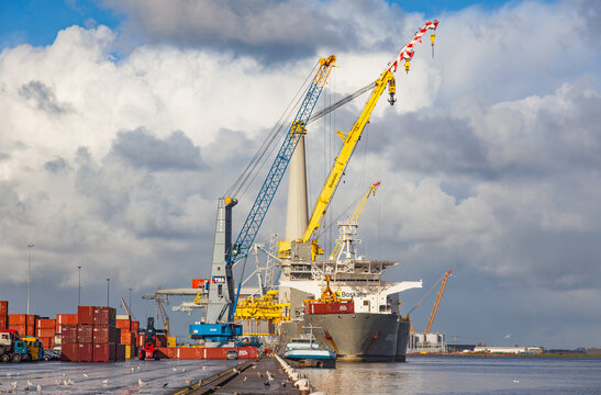 Amsterdam, Netherlands - July 20, 2026: Heavy Boskalis cargo ship and TMA harbor cranes loading containers at industrial port terminal