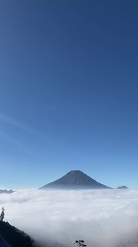 Panoramic view of sea of clouds over mountain peak with bright clear blue sky in highland above the clouds