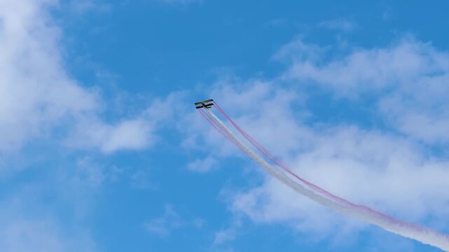 Aerobatic stunt aircrafts performing spectacular aerial maneuvers in the sky, releasing colorful smoke and fireworks. Team formation flight with white smoke trails. 4K video footage