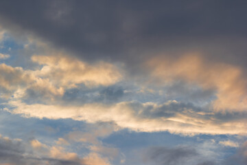 Obraz premium Dramatic dark storm clouds catching golden warm sunlight during sunset