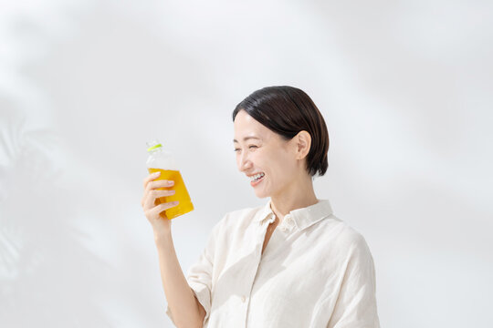 ペットボトルのお茶を飲む女性