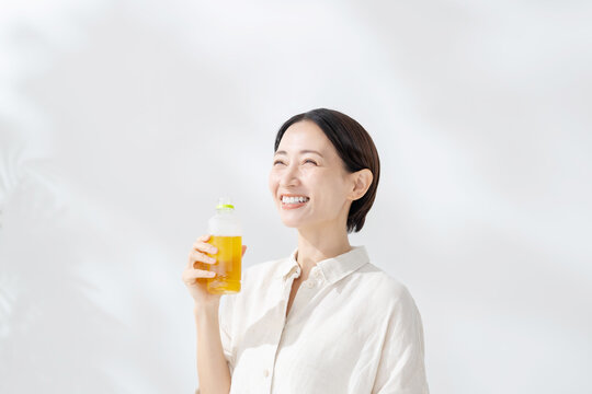 ペットボトルのお茶を飲む女性