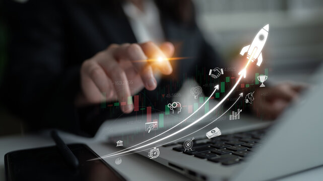 Business Professional Using Laptop with Financial Graphs and Rocket Icons Representing Growth and Innovation in Modern Workspace Sigmoid
