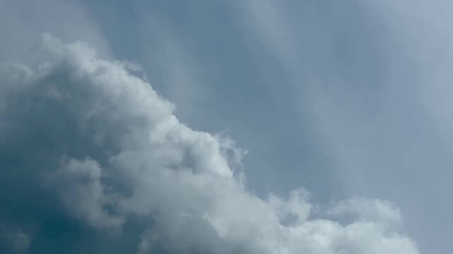 Dramatic White Cumulus Clouds Floating Across Blue Sky