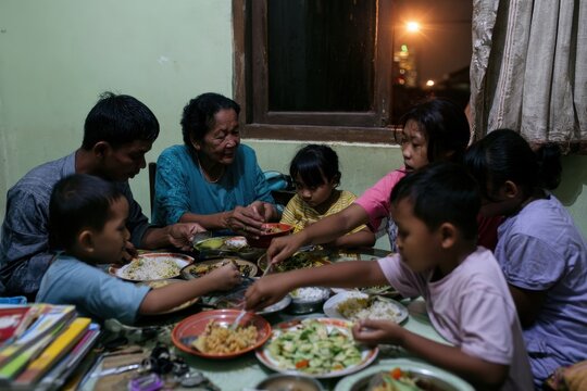 a multigenerational family gathers around a table sharing a meal together in an intimate home setting
