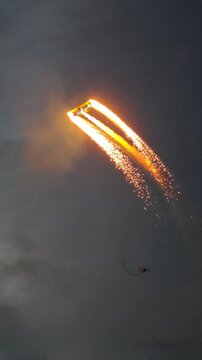 Aerobatic stunt aircrafts performing spectacular aerial maneuvers in the sky, releasing colorful smoke and fireworks. Team formation flight with white smoke trails. 4K vertical video footage