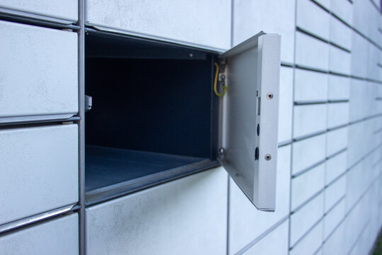 Open empty compartment door of an automated parcel locker with visible hinge mechanism