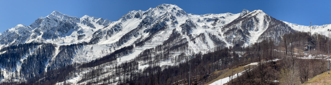 Snow-capped peaks rise sharply against clear blue sky