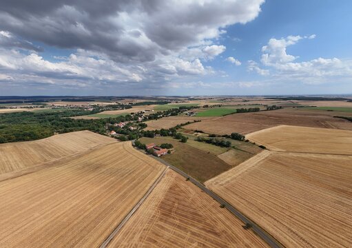 Vue a&eacute;rienne panoramique du village de Saint Supplet, en Meurthe-et-Moselle, entour&eacute; des champs apr&egrave;s la moisson en juillet 2026. Gros  nuages cumulus avec du soleil et un ciel bleu. Paysage rural
