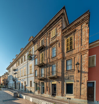 Historic red brick building facade in via Peveragno in old town of Cuneo, Piedmont, Italy. Traditional Italian heritage architecture with classic windows and vintage style