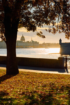 Isaac cathedral, Winter Palace, picturesque metal railings with a double-headed eagle and the crown of the Russian Empire on embankment in St. Petersburg, autumn sunset, incredible sun glare, Russia