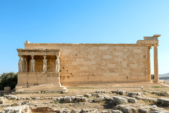 The Erechtheion temple with its Caryatid porch stands in sunlight on the Acropolis of Athens, Greece, a masterpiece of ancient Greek architecture.
