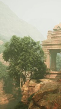 A dense fog covers an ancient temple in a mountainous area. Large trees and rocky formations surround the structure. Nature blends with the historical landscape in this scene.