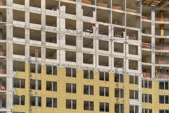 External wall insulation layers with mineral wool panels on a multi-story residential building facade under construction. 