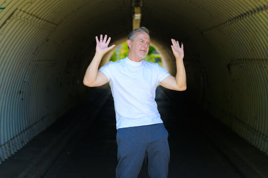 Expressive Mature Man Raising Hands