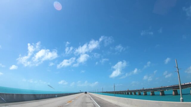 POV driving across the iconic Seven Mile Bridge in the Florida Keys with turquoise ocean, scenic coastal views and a sunny tropical atmosphere.
