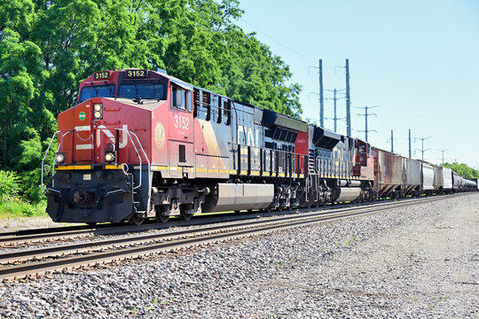 A westbound merchandise freight train on Burlington Northern Santa Fe tracks, is led by two Canadian National Railway locomotives as it pases through northern Illinois.