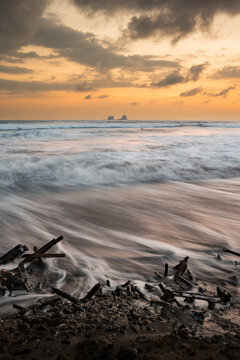 Sunset seascape with driftwood on Ayampe beach, Ecuador