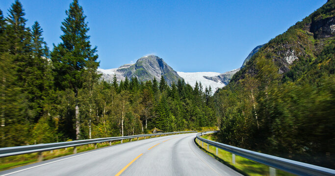 Road trip driving through norwegian valley with glacier