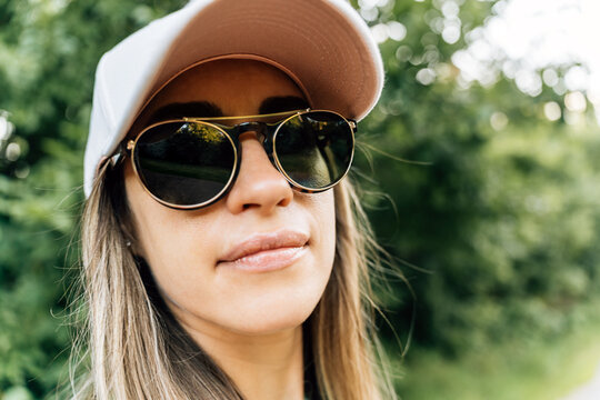 Woman in sunglasses and cap enjoying a summer day