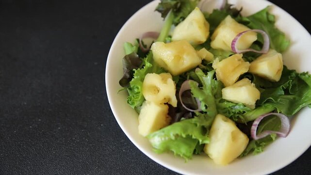 Pineapple Salad mixed green salad leaves and pineapple chunks food preparation tasty snack fresh gourmet food background on the table rustic food top view copy space keto and paleo diets vegetarian an