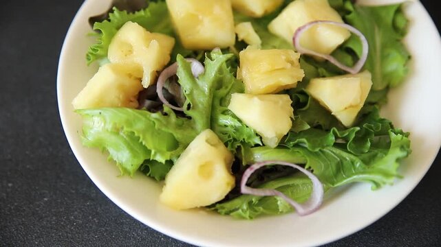 Pineapple Salad mixed green salad leaves and pineapple chunks food preparation tasty snack fresh gourmet food background on the table rustic food top view copy space keto and paleo diets vegetarian an