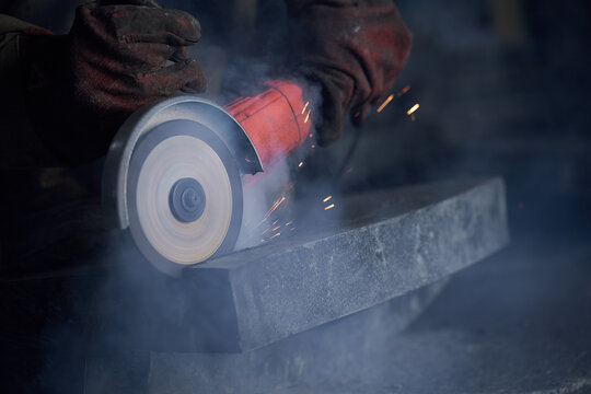 Worker use angle grinder to cut steel beam