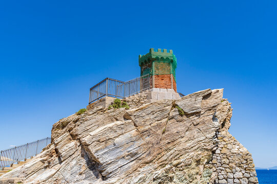 Ancient tower structure in rio marina elba island on rugged cliff with blue sky and ocean
