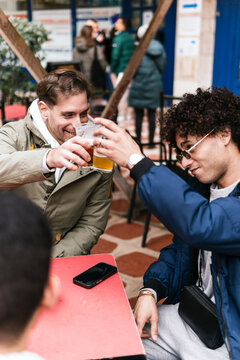Friends enjoying beer at a lively bar terrace