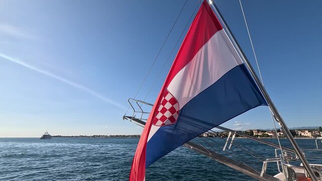 Croatian flag flapping in the wind on a boat sailing on the adriatic sea during a sunny day