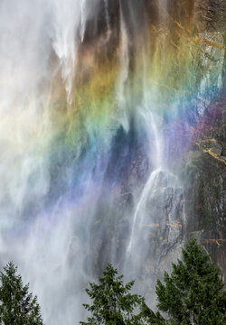 Rainbow mist over waterfall cliff in Yosemite valley