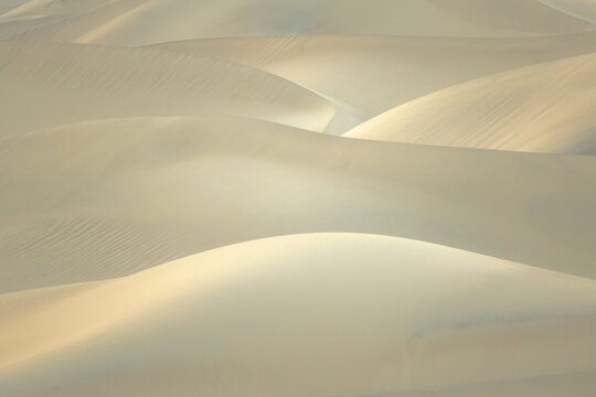 Soft sand dunes in Death Valley desert with drifting haze