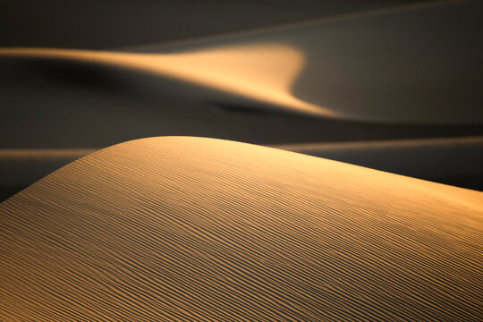 Golden sand dune texture in Death Valley desert at sunset