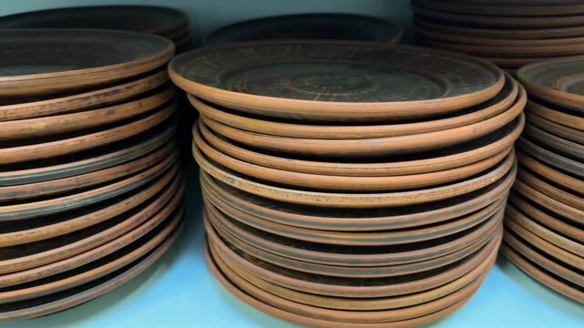 Neatly stacked earthenware plates create an attractive retail display, highlighting durable clay tableware suitable for serving meals, home kitchens and traditional dining. Close up.