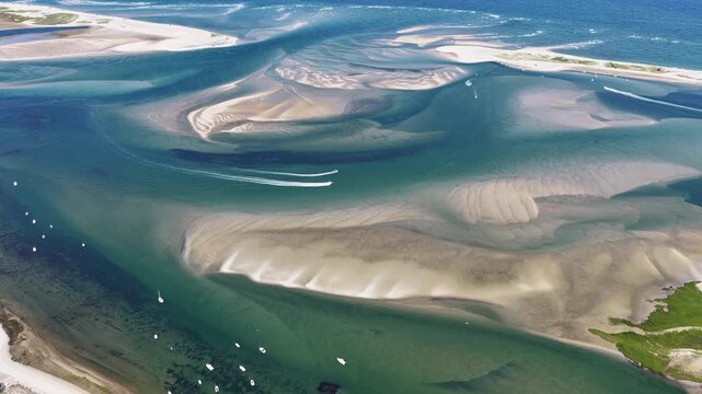 Currents from the Atlantic Ocean continuously shape the sand bars and scenic beaches of Cape Cod, Massachusetts. The entire peninsula is in constant movement due to its geologic makeup of mostly sand.