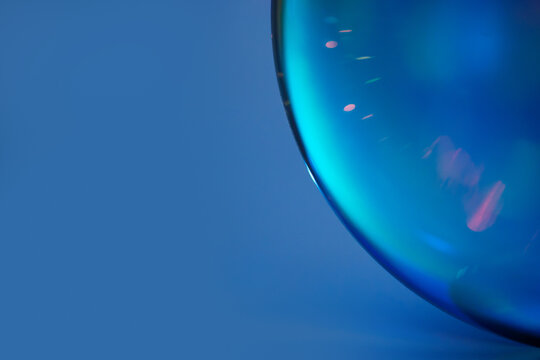 Blue abstract glass sphere with luminous reflections