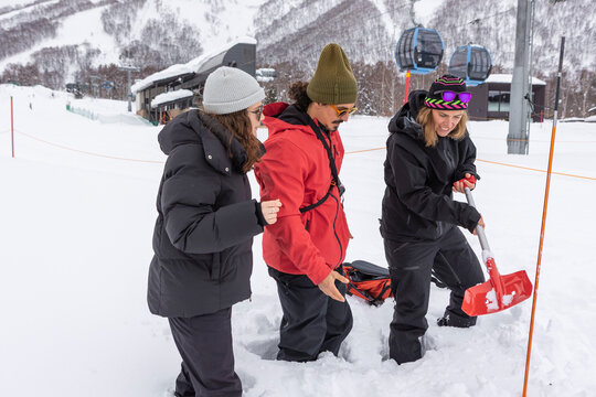 Woman practicing snow shoveling during avalanche course