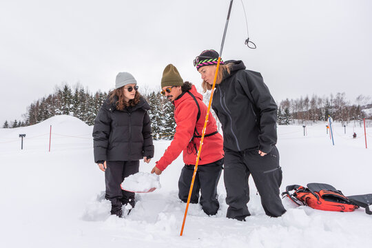 Group examining snow during avalanche rescue training