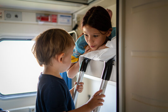 Children explore bunk bed during family train journey