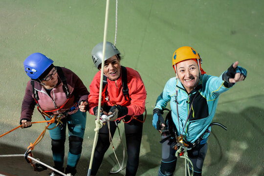 Women practice vertical caving technique at indoor gym