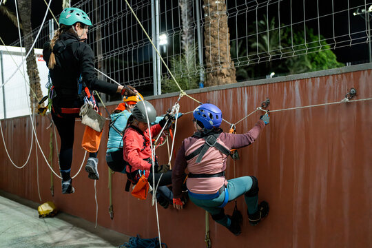 Women practice vertical caving training at outdoor gym