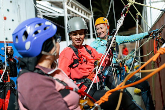 Women practice vertical caving rope technique at gym