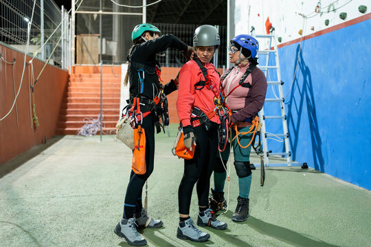 Women prepare for caving training at indoor climbing gym