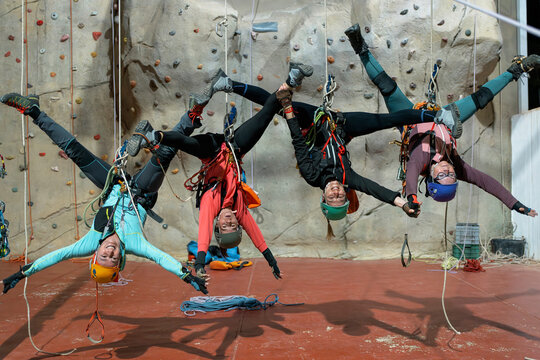 Women practice indoor climbing and vertical rope techniques