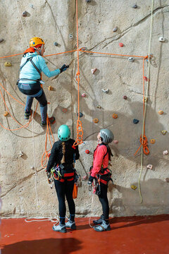 Women practice indoor climbing and vertical rope training