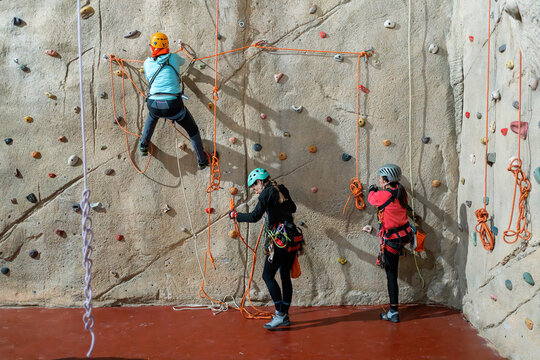 Women climb indoor wall during vertical training session