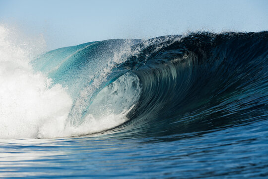 Powerful ocean wave curling into barrel with sea spray