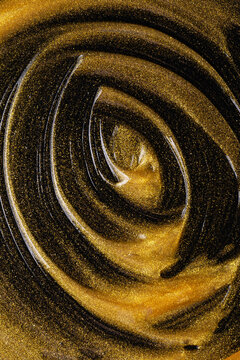 Gold oil cosmetic texture with shimmering abstract swirl